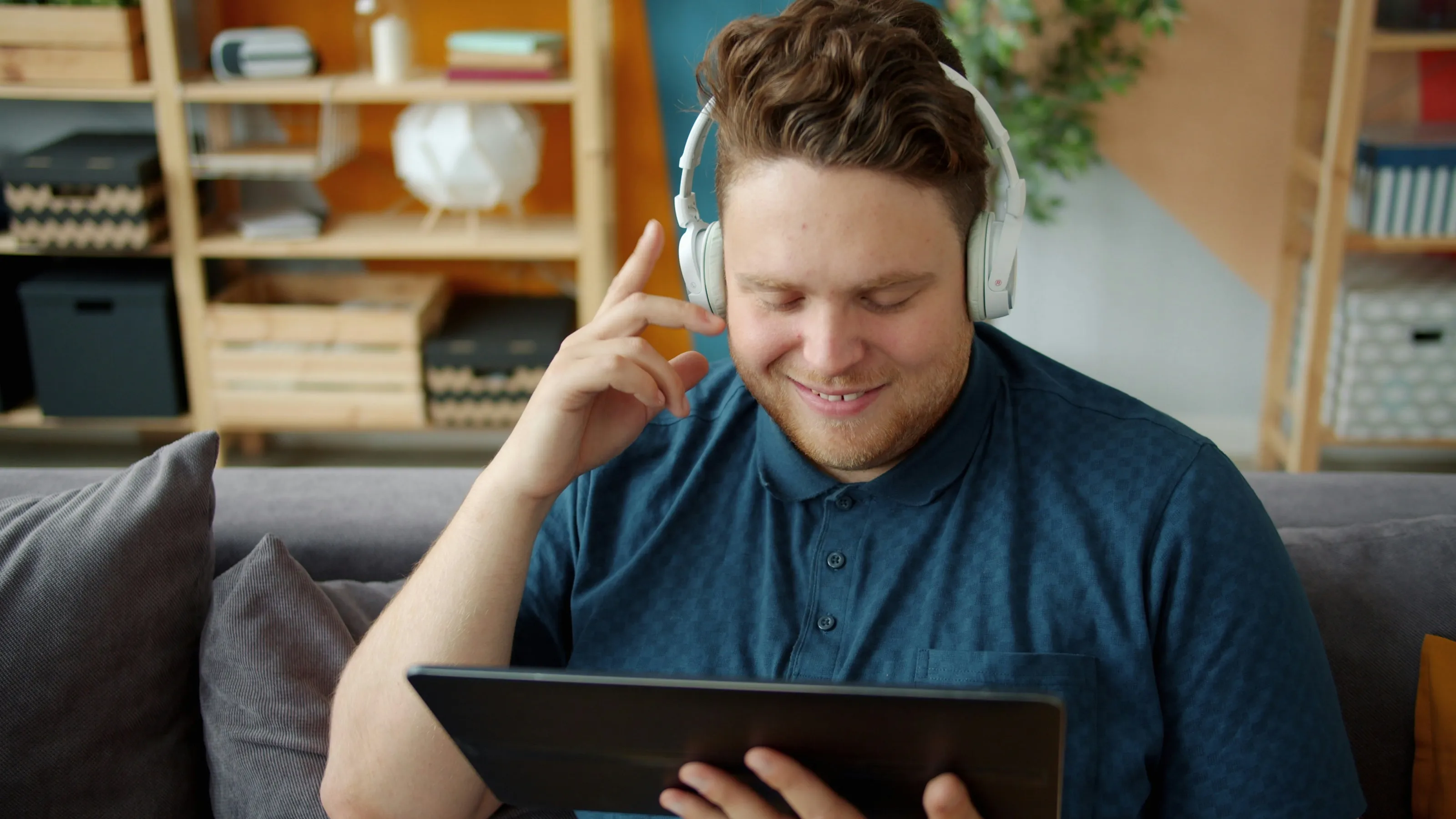 A man with headphones following a course on his tablet