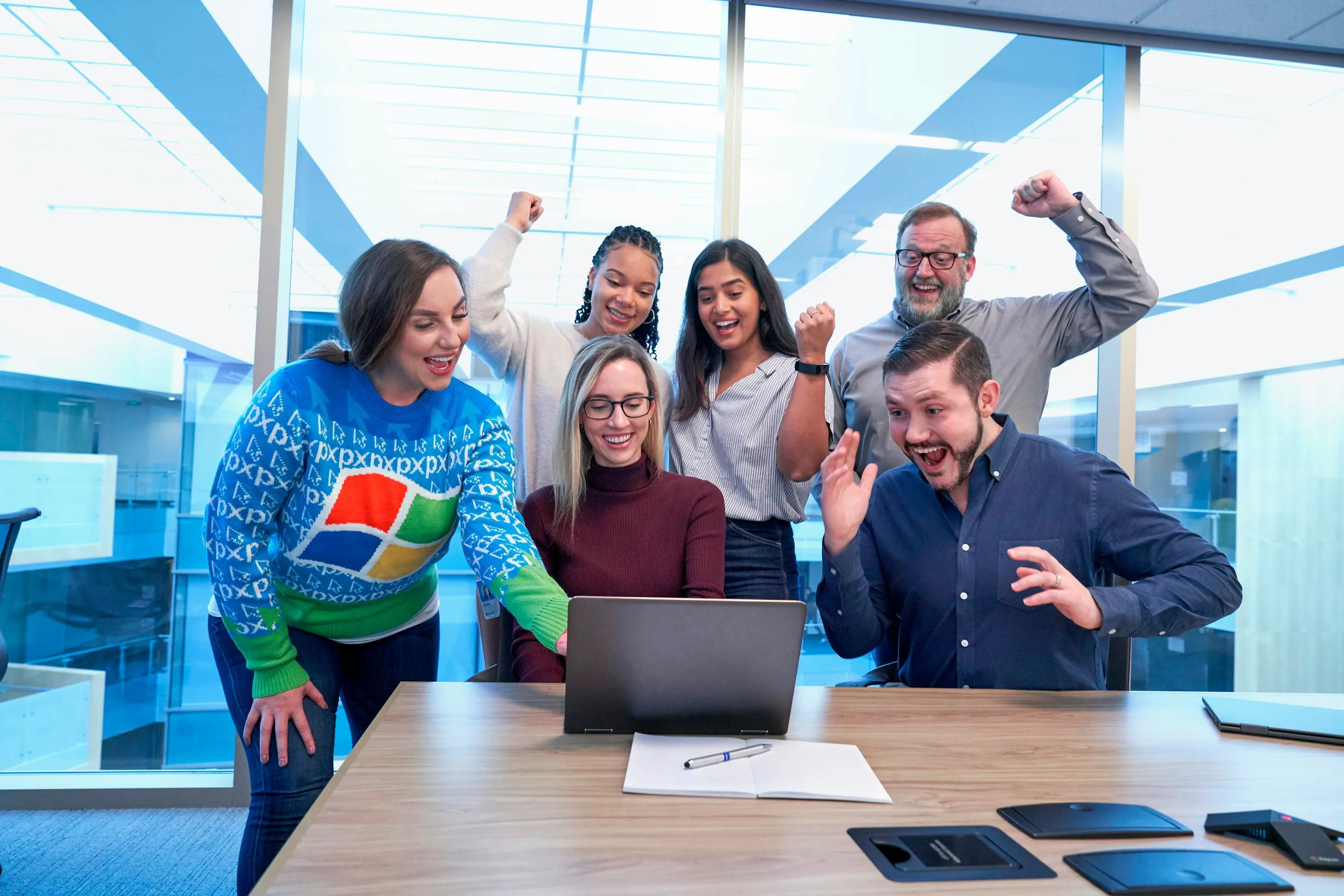 A team celebrating good news around a laptop